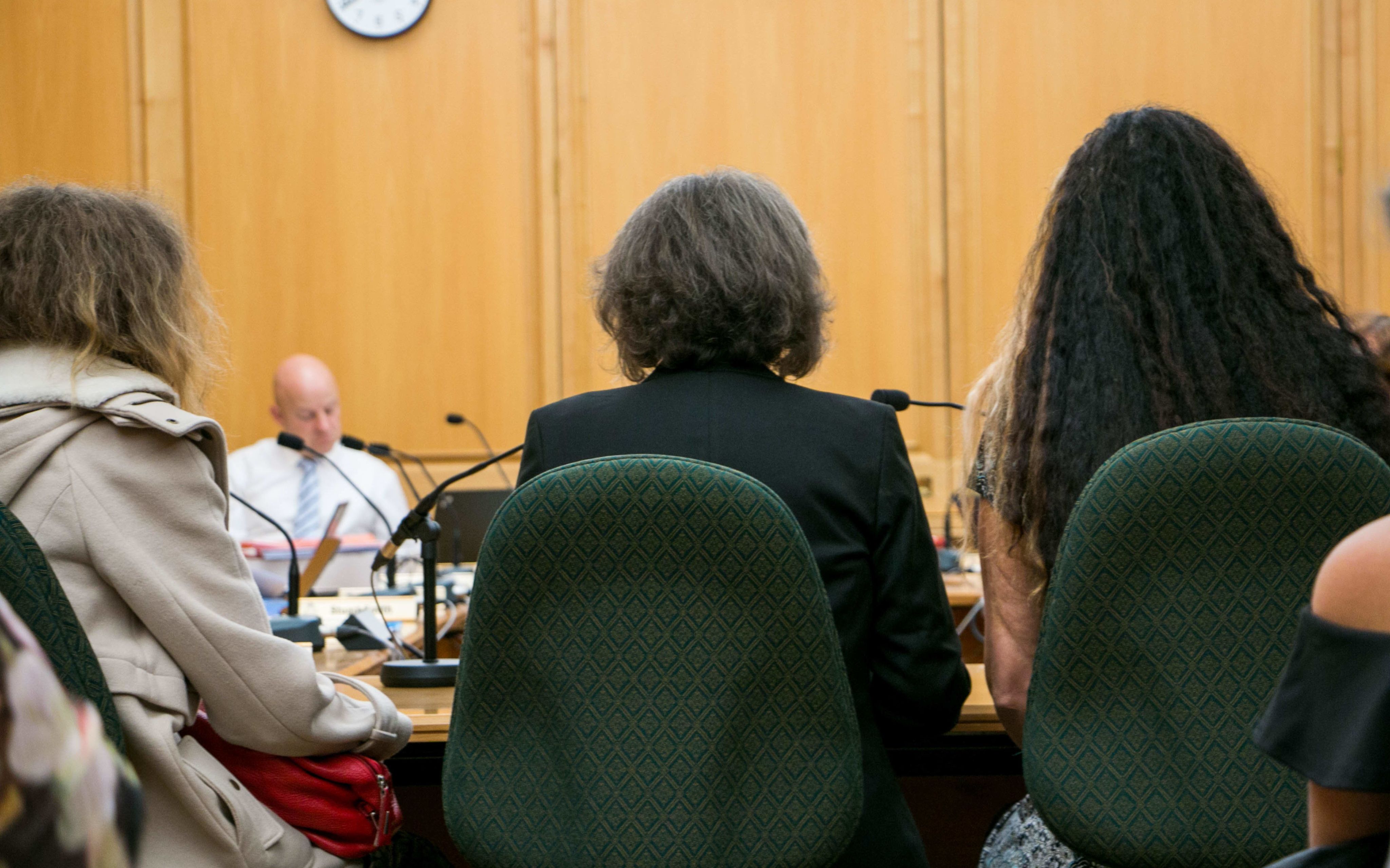 the backs of three women sitting in court