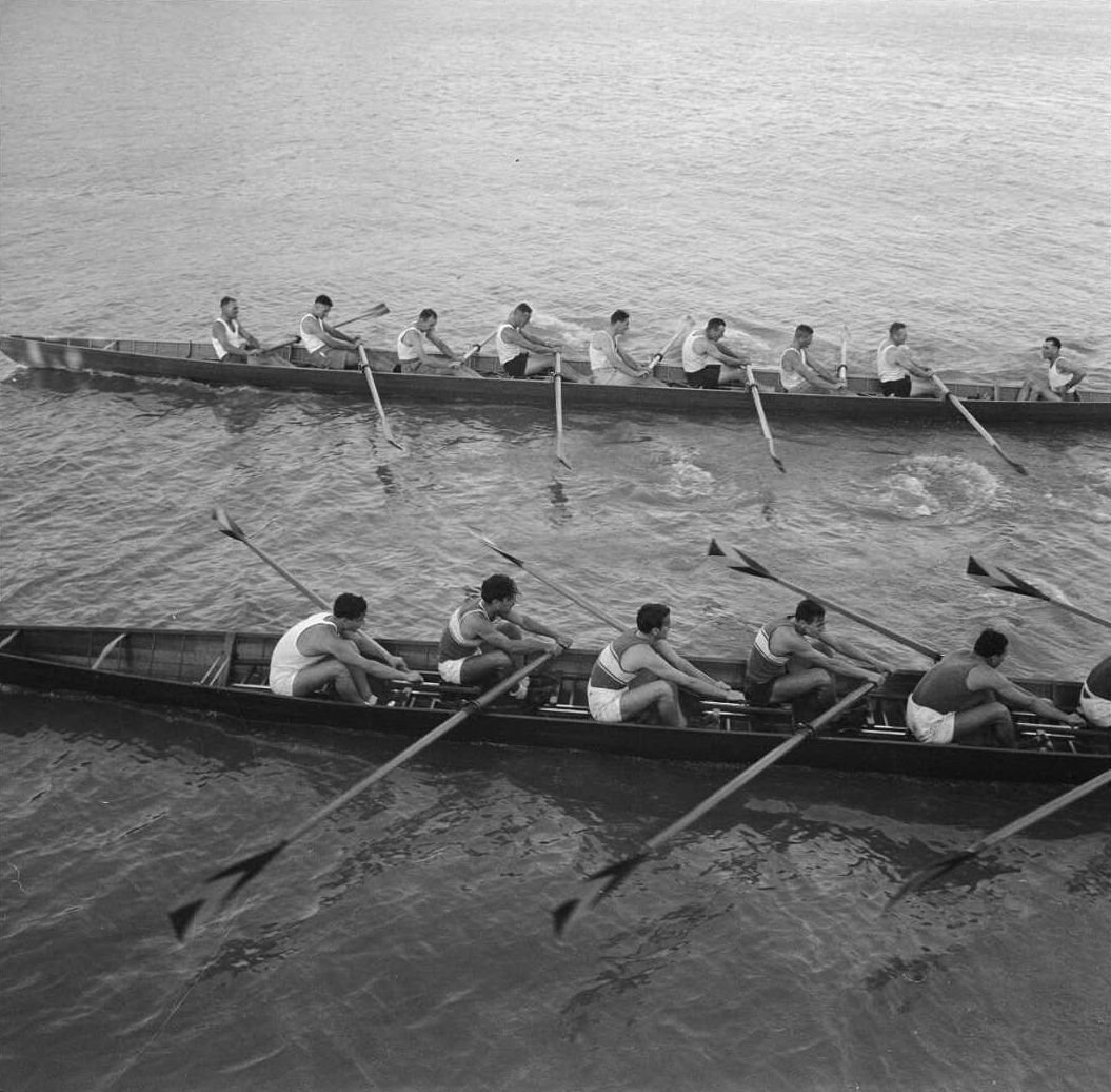 Black and white photo of two rowing eight boats and crew