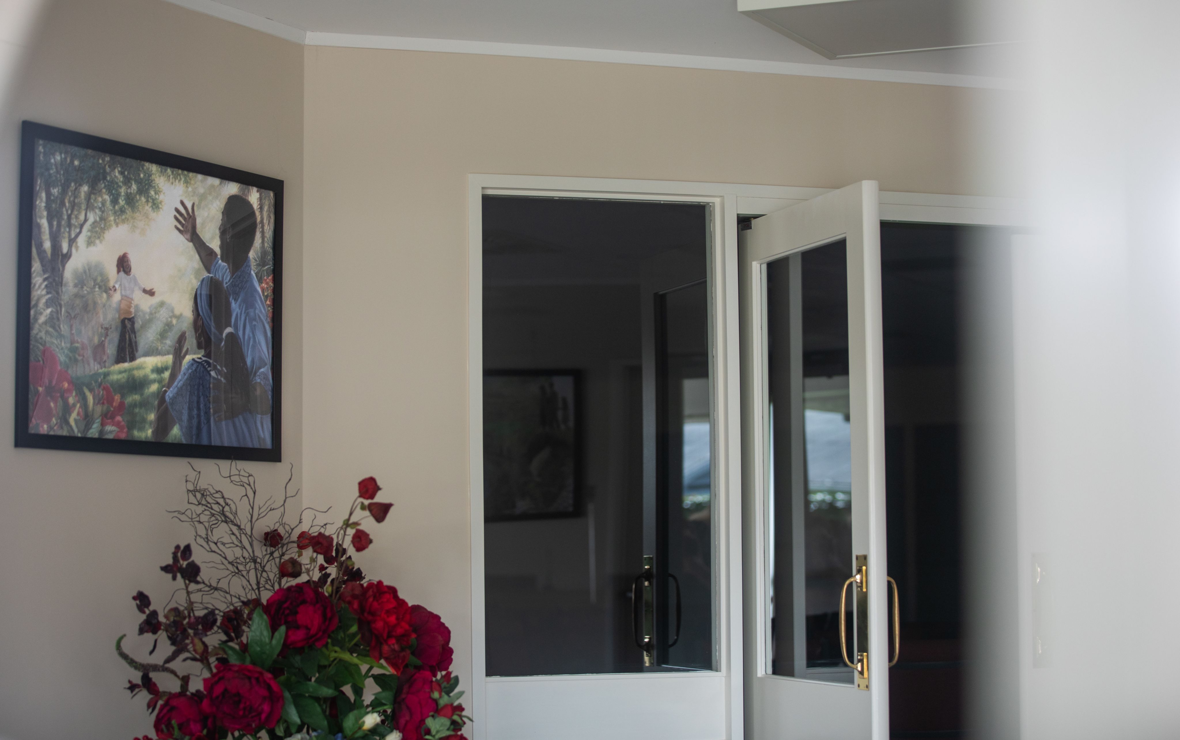 Framed art hangs on a wall inside a Kingdom Hall of Jehovah's Witnesses